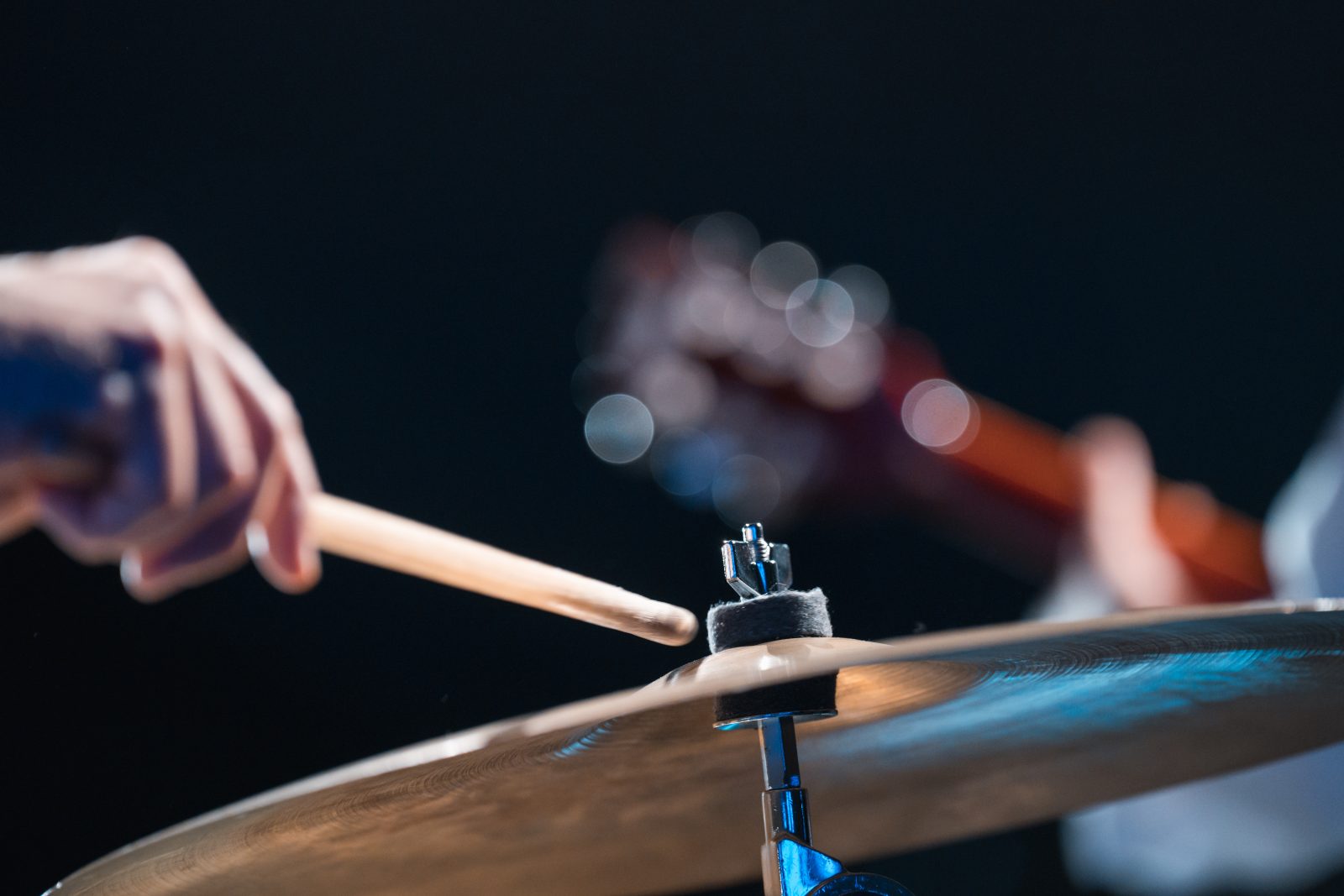Die Hand eines Schlagwerkers in Nahaufnahme auf einer Bühne des Festivals Montafoner Resonanzen, im Hintergrund ein Gitarrist mit Akustikgitarre